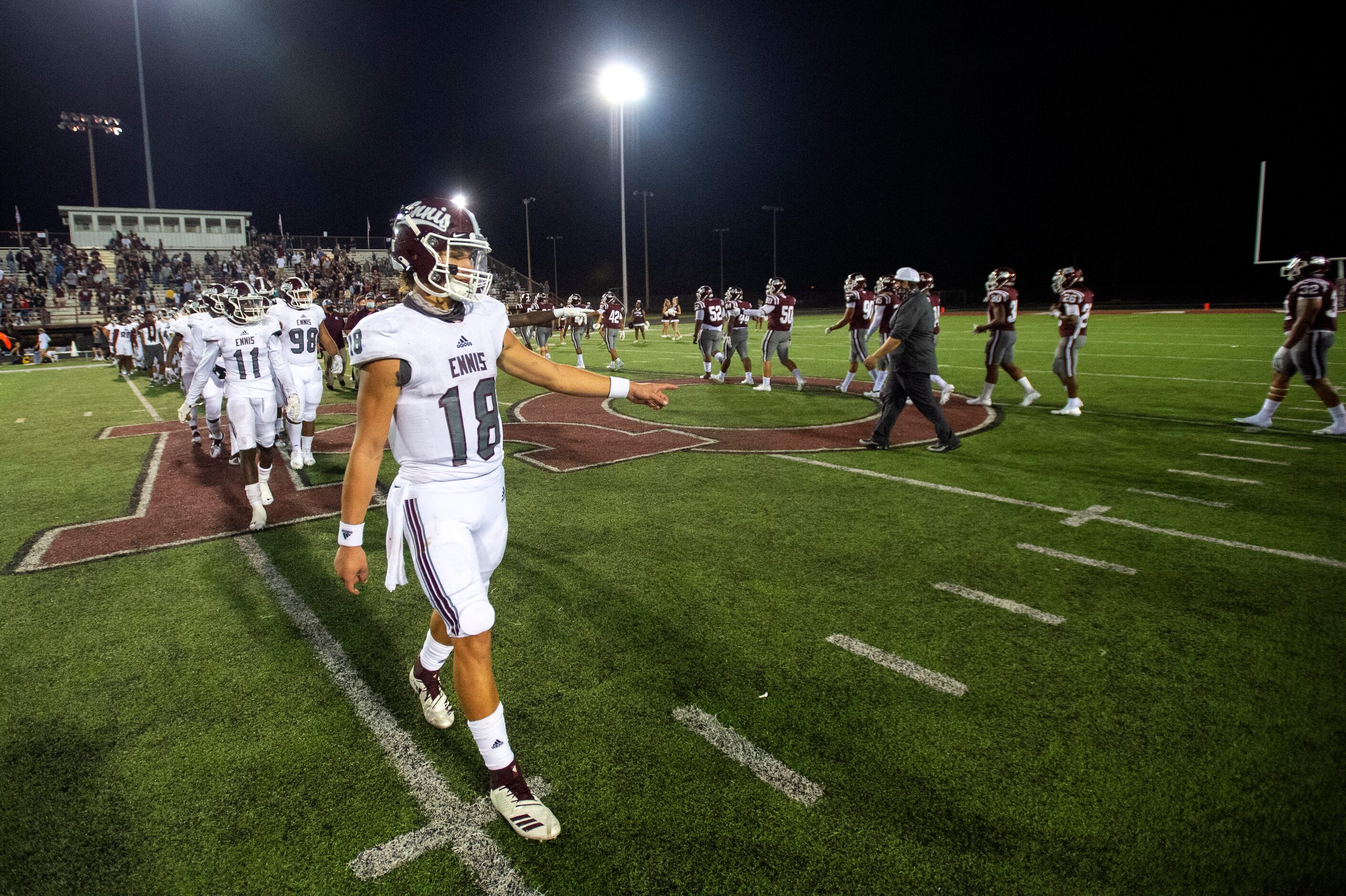 Ennis senior quarterback Collin Drake leads his team through the postgame handshake line...