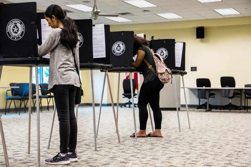 Zuleima Martínez  (izq.) y Sananda McCall, ambas de Arlington, ejercen su voto en una...