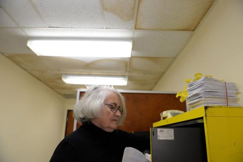 
Executive Director Mary Rakowitz looks through the files of previous clients at Oak Cliff...