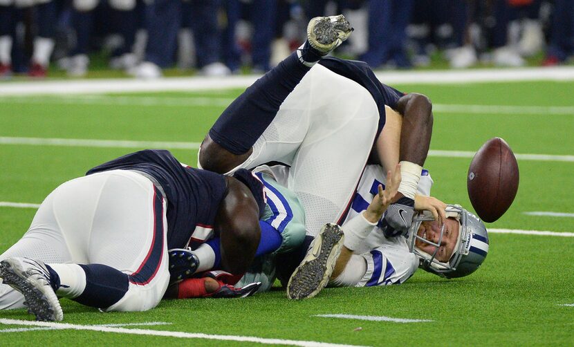 Dallas Cowboys quarterback Cooper Rush (7) fumbles the ball as he is hit by Houston Texans...