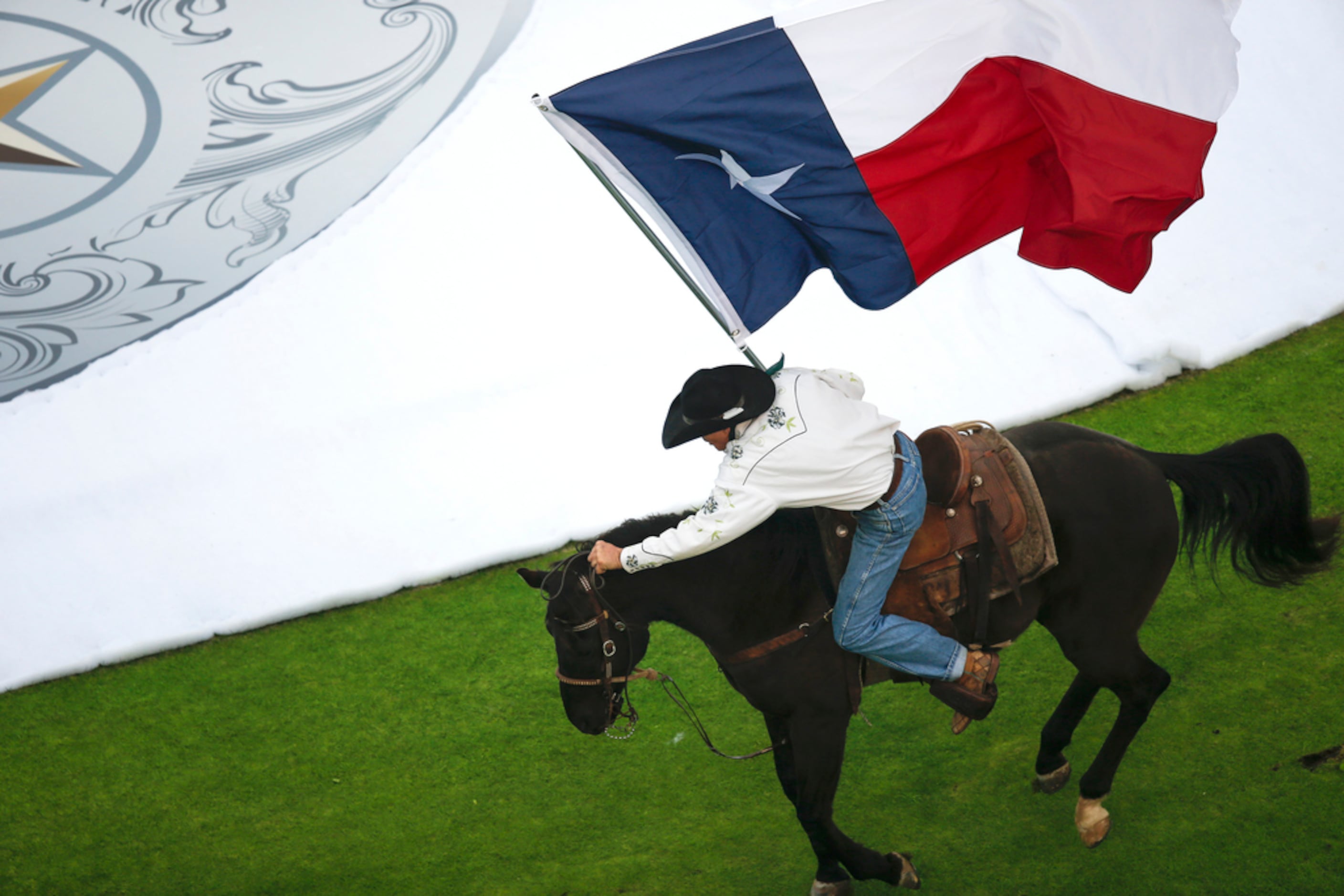 The Texas flag is run across the field horseback prior to a NHL Winter Classic matchup...