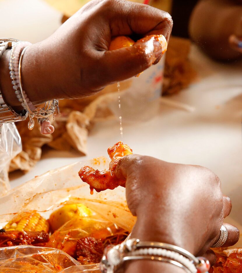 Anissa Collins-Fortune squirts lemon onto shrimp at The Boiling Crab in Dallas.