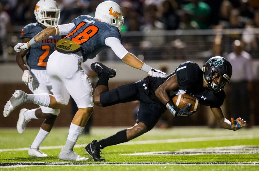 Mansfield Lake Ridge wide receiver Malik Knowles (18) falls in to the end zone for a...