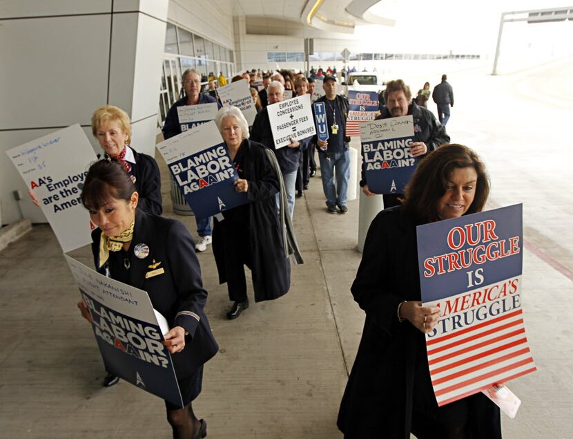 Employees of American Airlines picket outside of Terminal D Tuesday, February 14, 2012 at...