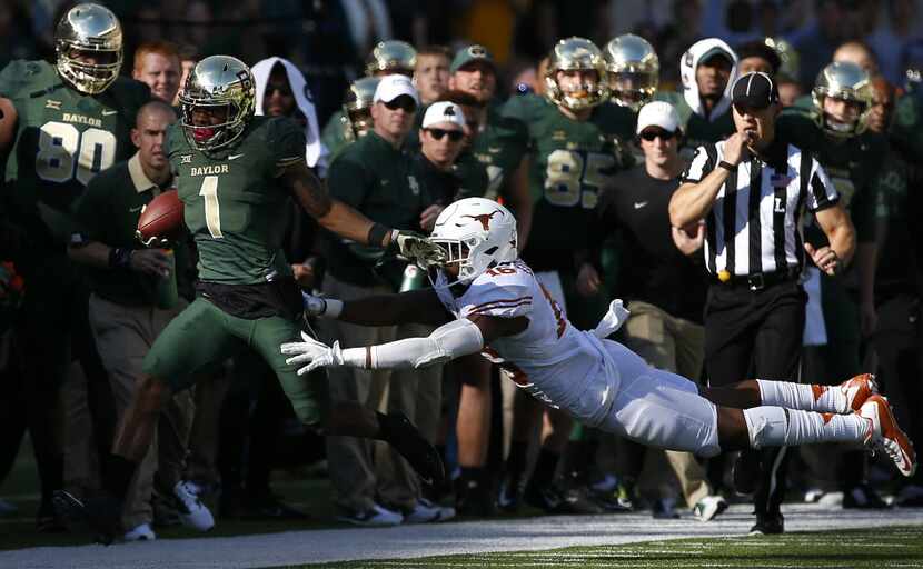 Baylor wide receiver Corey Coleman (1) is pushed out of bounds by Texas defensive back...