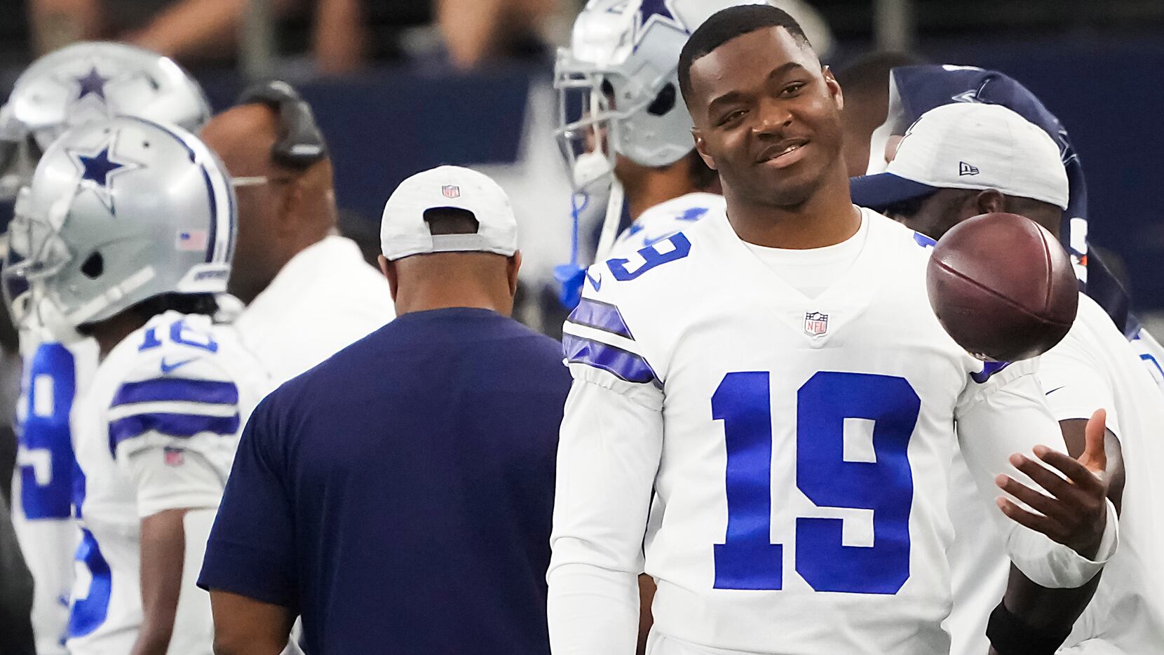 Dallas Cowboys wide receiver Amari Cooper tosses a ball on the sidelines during the first...