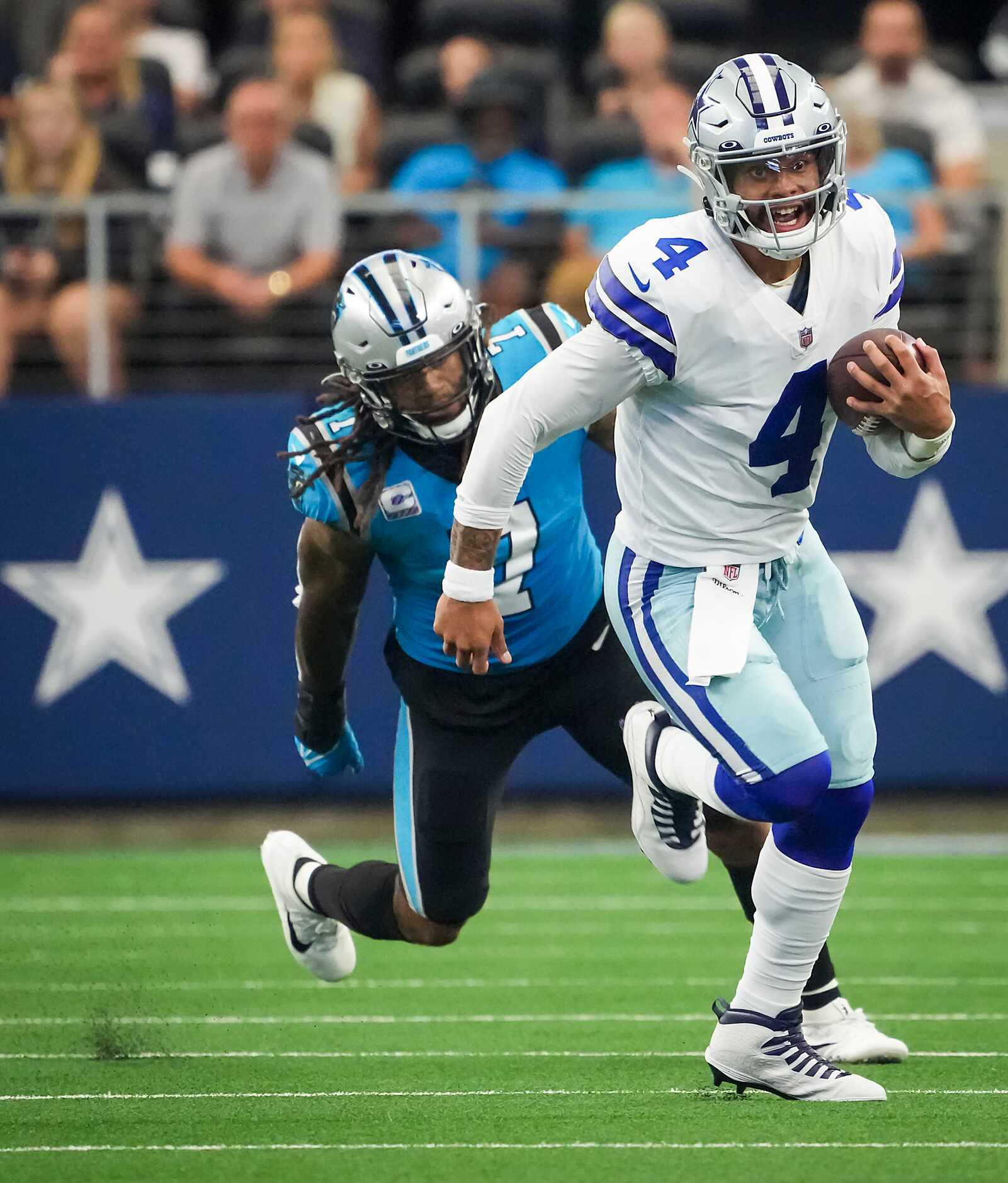 Dallas Cowboys quarterback Dak Prescott (4) scrambles away from Carolina Panthers outside...