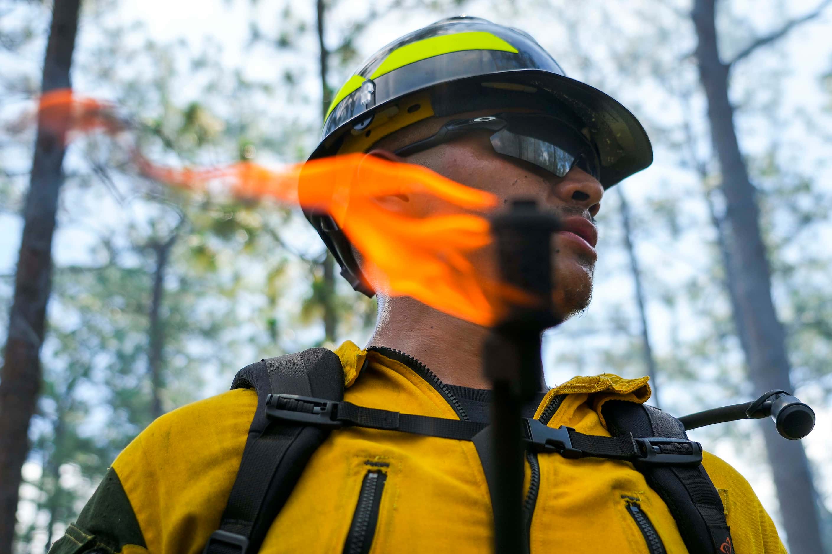 Adrian Thompson of the Alabama-Coushatta Wildland Fire Management stands ready with a drip...