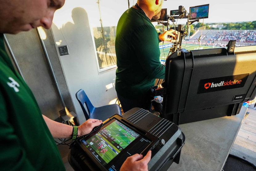 Waxahachie’s Matthew McCullough (right) operates the team’s press box level video cameras as...