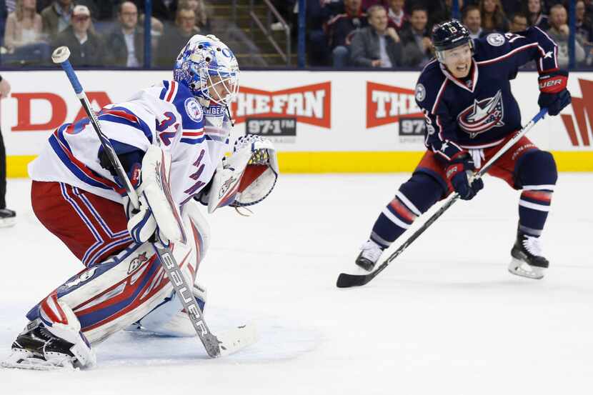 New York Rangers' Antti Raanta, left, of Finland, protects the net as Columbus Blue Jackets'...