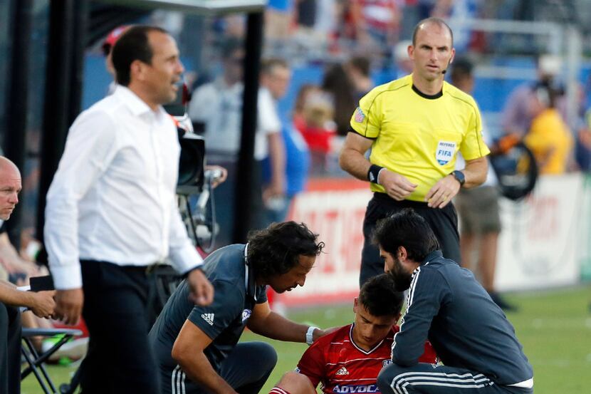 FC Dallas midfielder Mauro Diaz, center bottom, is assisted by team staff after suffering...