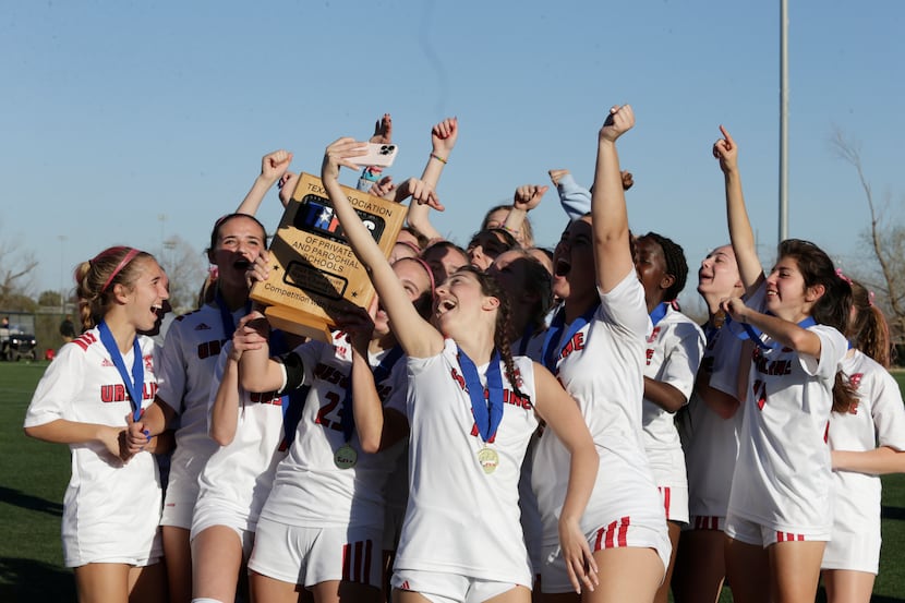Lily Marquez of the Ursuline girls soccer team takes a team selfie with the TAPPS trophy...