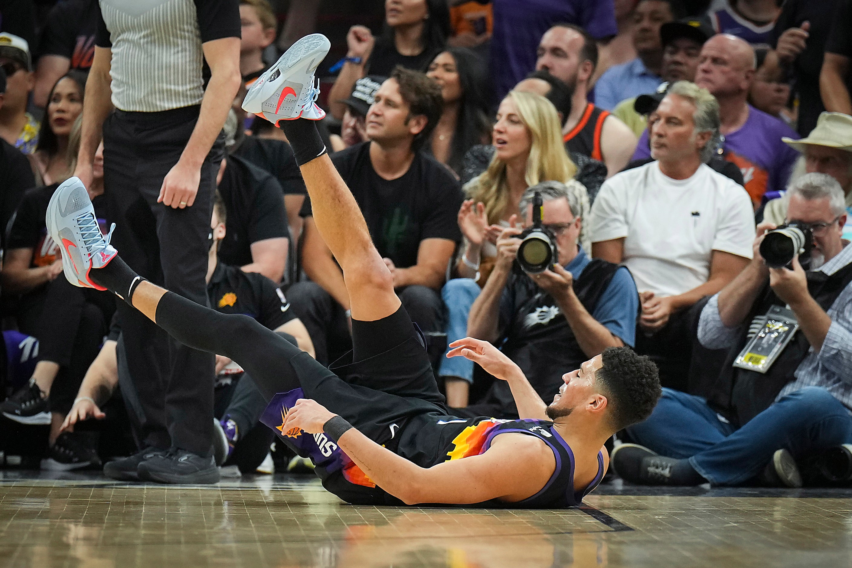 Phoenix Suns guard Devin Booker (1) falls to the floor after a shot during the first quarter...