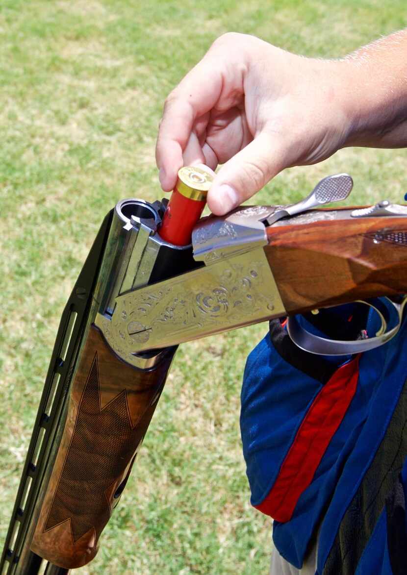 
Senior Hunter Alford, 17, loads a 12-gauge shell into his shotgun for skeet-shooting...