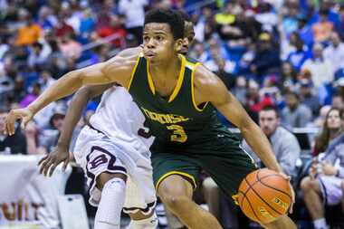 Madison guard Admon Gilder (3) makes his way past Bridgeport guard Keenan Holdman (5) during...