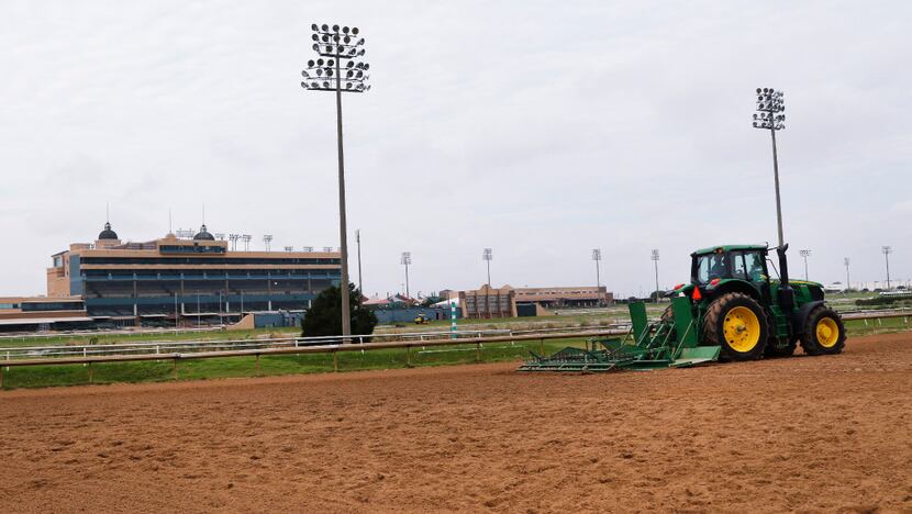 A Lone Star Park employee prepares the horse track to get ready for the opening of...