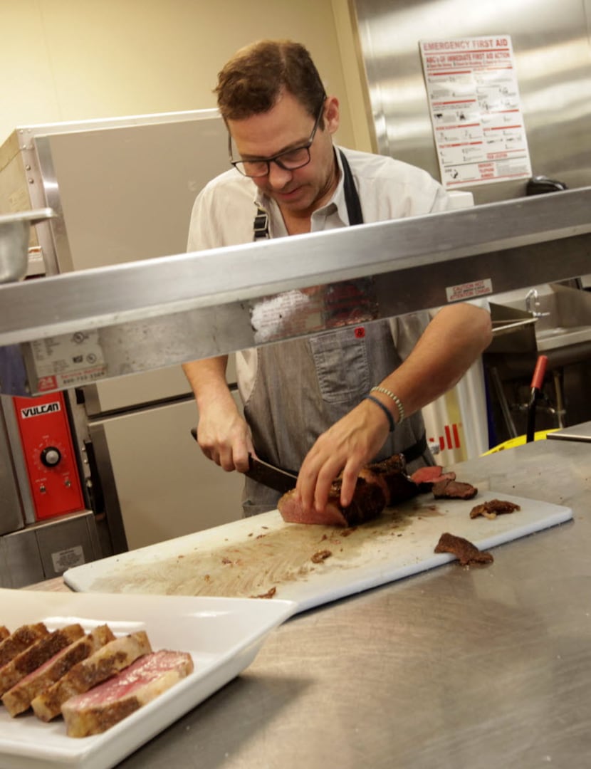 John Tesar prepares a meal during the EAT (RED) DRINK (RED) SAVE LIVES dinner featuring chef...