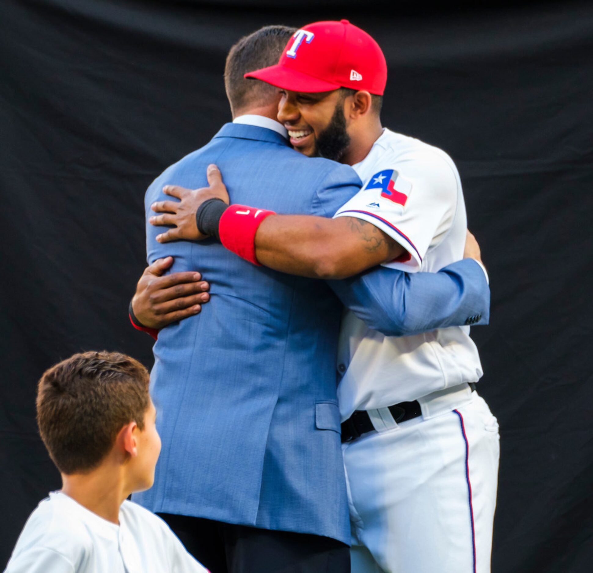 Michael Young hugs Texas Rangers shortstop Elvis Andrus  during ceremonies to retire Young's...