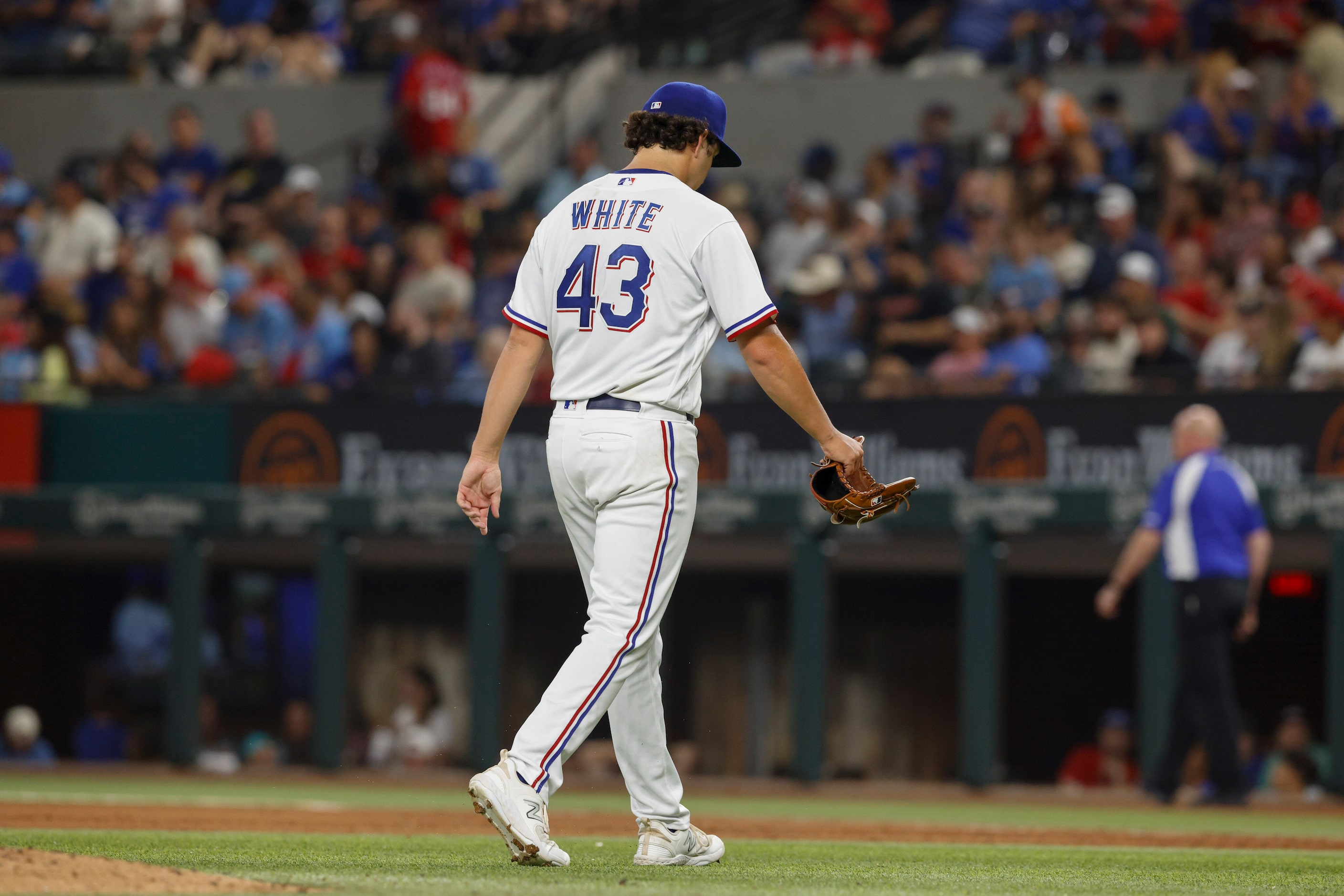 Texas Rangers relief pitcher Owen White (43) drops his head as he heads to the dugout after...