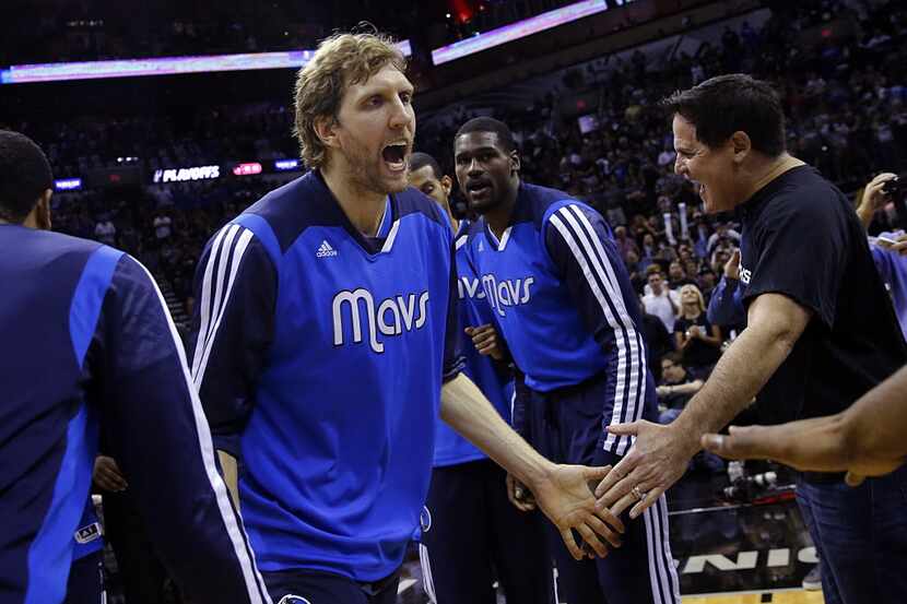 Dallas Mavericks forward Dirk Nowitzki (41) slaps hands with owner Mark Cuban as he is...