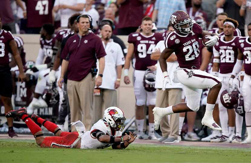 Texas A&M running back Isaiah Spiller (28) is tripped up by Lamar defensive back Michael...