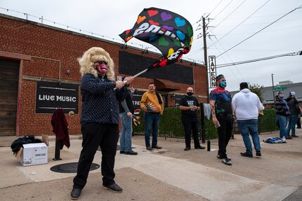 Larry Farris, 36, of Dallas, waves a flag with printing that reads "#LOVEWINS" as men and...