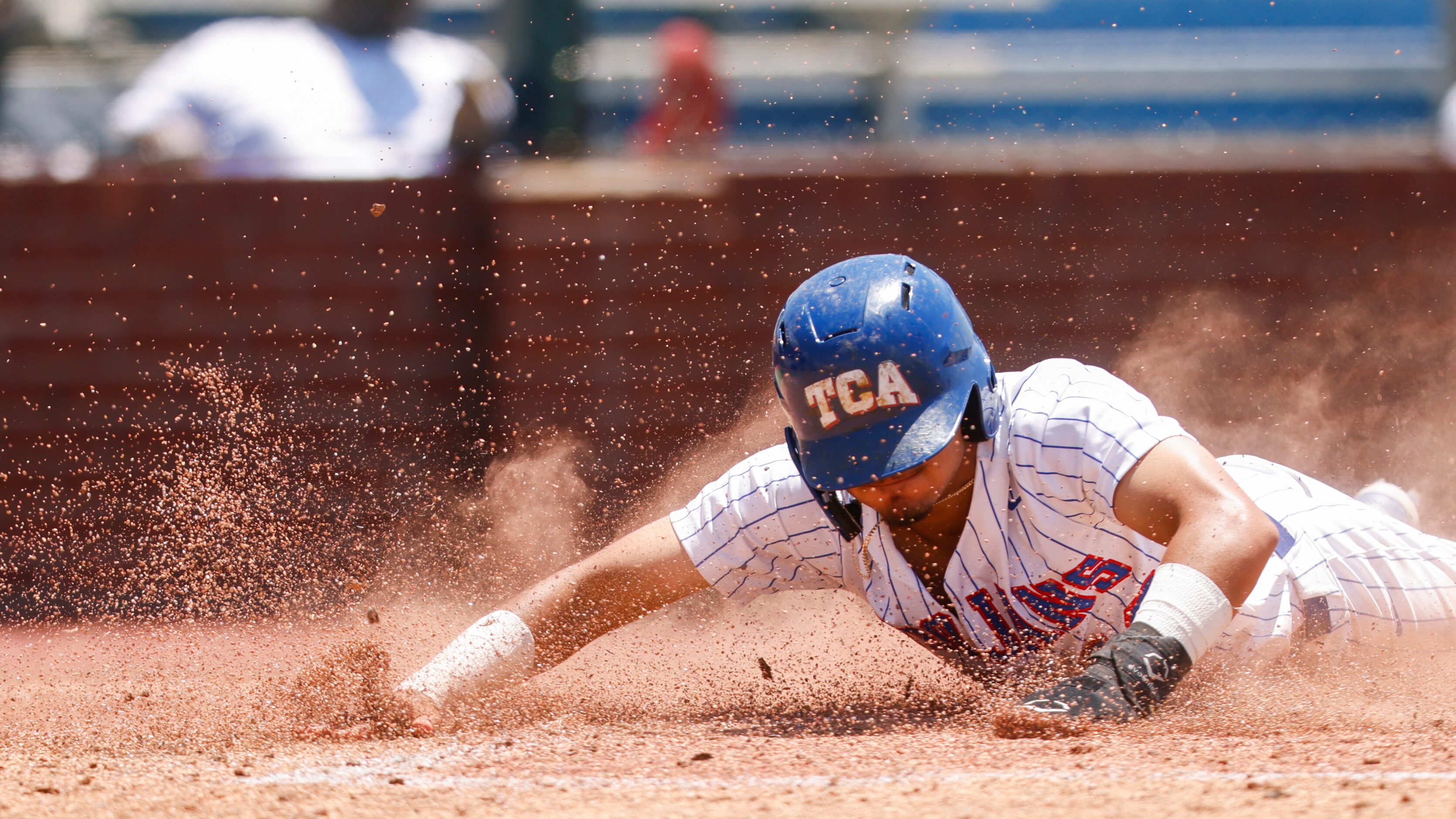 Trinity Christian’s Steven Ramos (12) slides into home in the third inning against Houston...