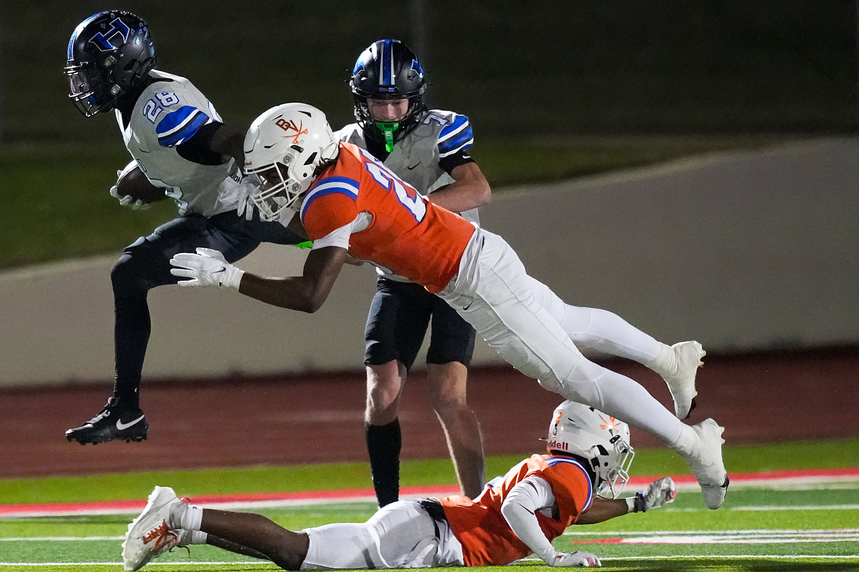 Hebron running back Marcus Nathaniel-Johnson (28) leaps over Arlington Bowie defensive back...