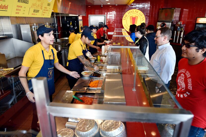 Food server Elijah Layton, left, takes an order from Amann Islam at the new The Halal Guys...