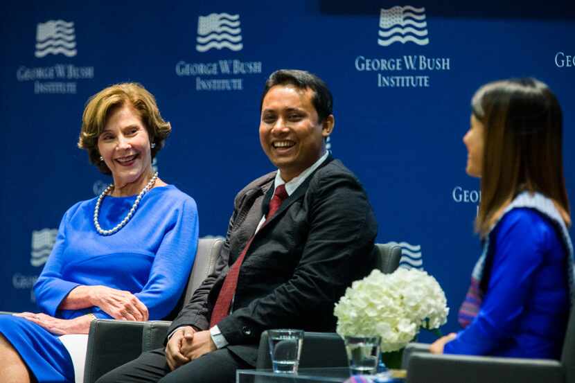 Former First Lady Laura Bush speaks on a panel with graduates Aung Kyaw Moe, center, and Ei...