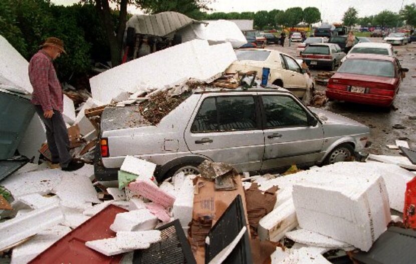 Jose Caballero, an usher at Fair Park Music Hall, inspects his car in May 1995 after...