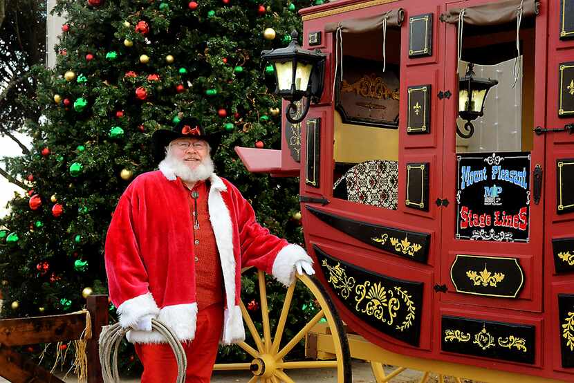 A cowboy version of Santa Claus stands next to a stagecoach in Mount Pleasant, TX.