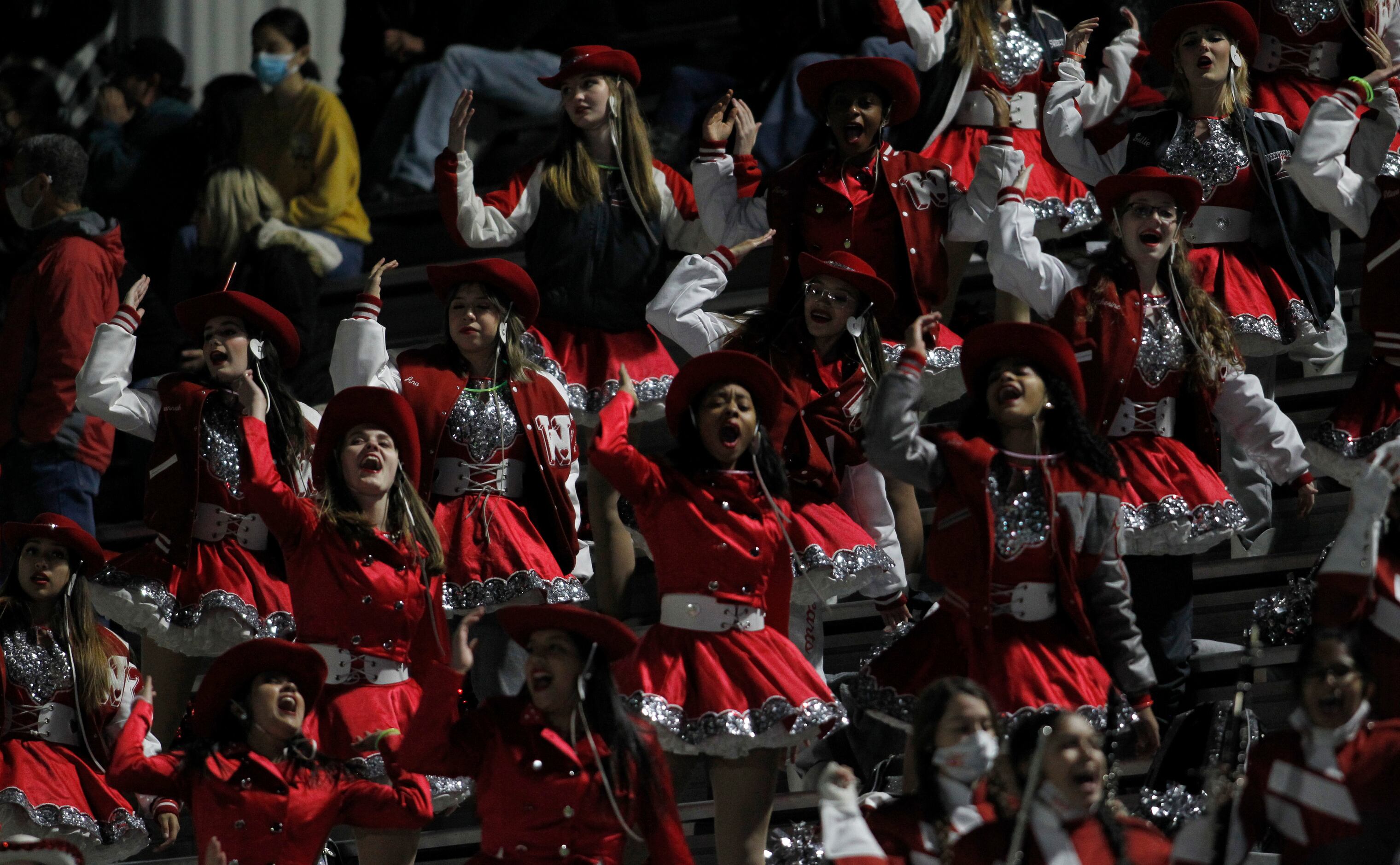 Members of the Dallas Woodrow Wilson drill team vocalize their support from the stands...