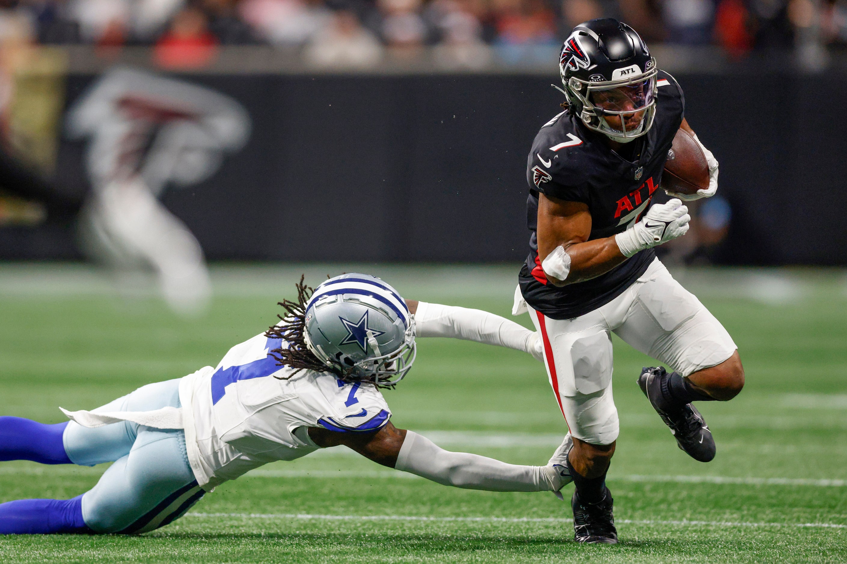 Dallas Cowboys cornerback Trevon Diggs (7) dives at the legs of Atlanta Falcons running back...