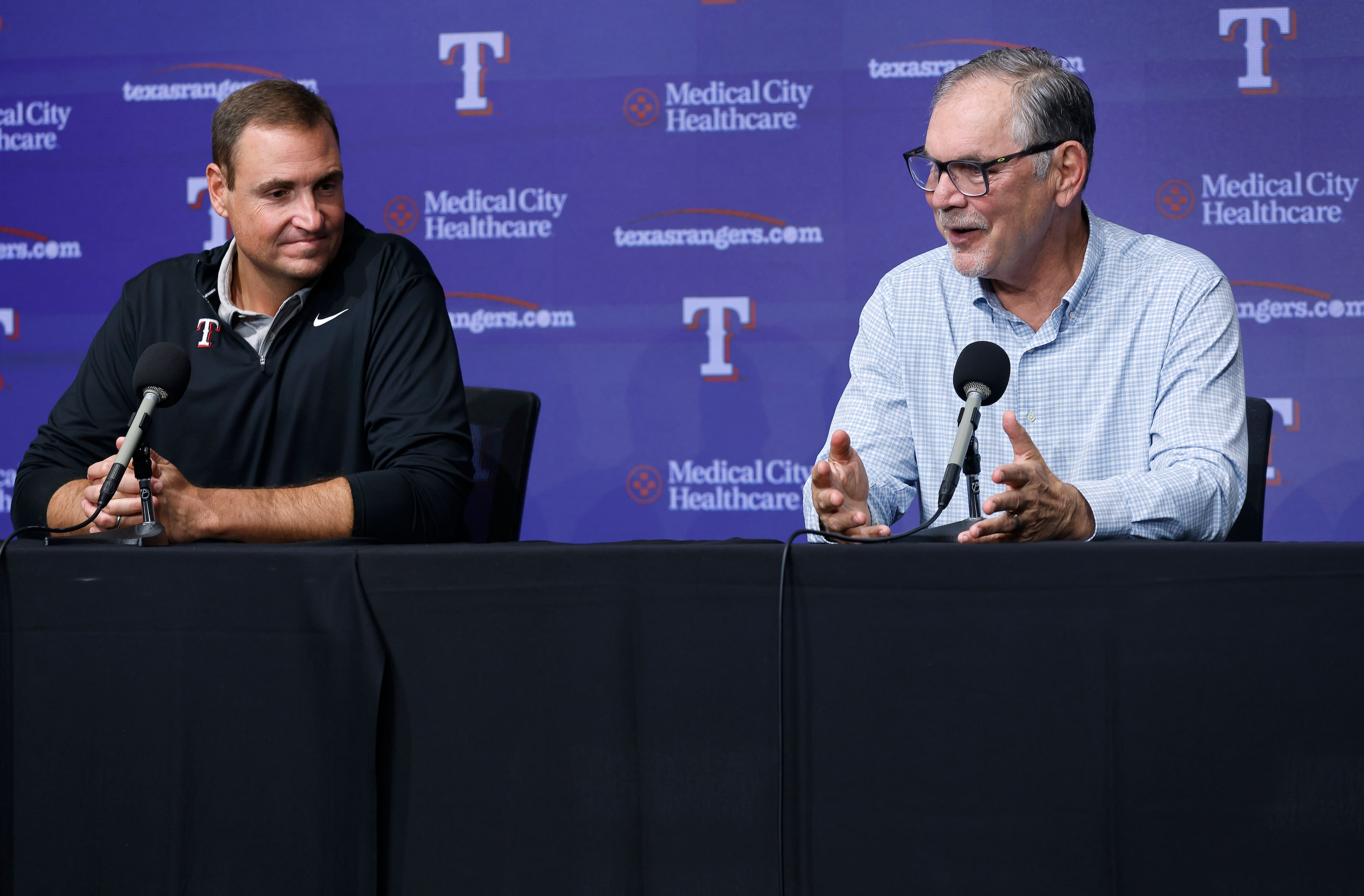 Alongside general manager Chris Young (left), Texas Rangers manager Bruce Bochy responds to...