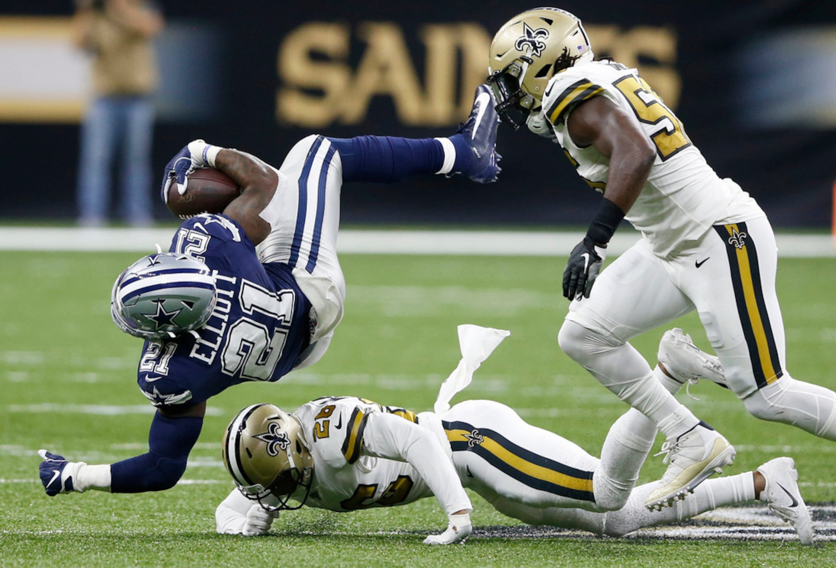 Dallas Cowboys running back Ezekiel Elliott (21) is tackled by New Orleans Saints cornerback...