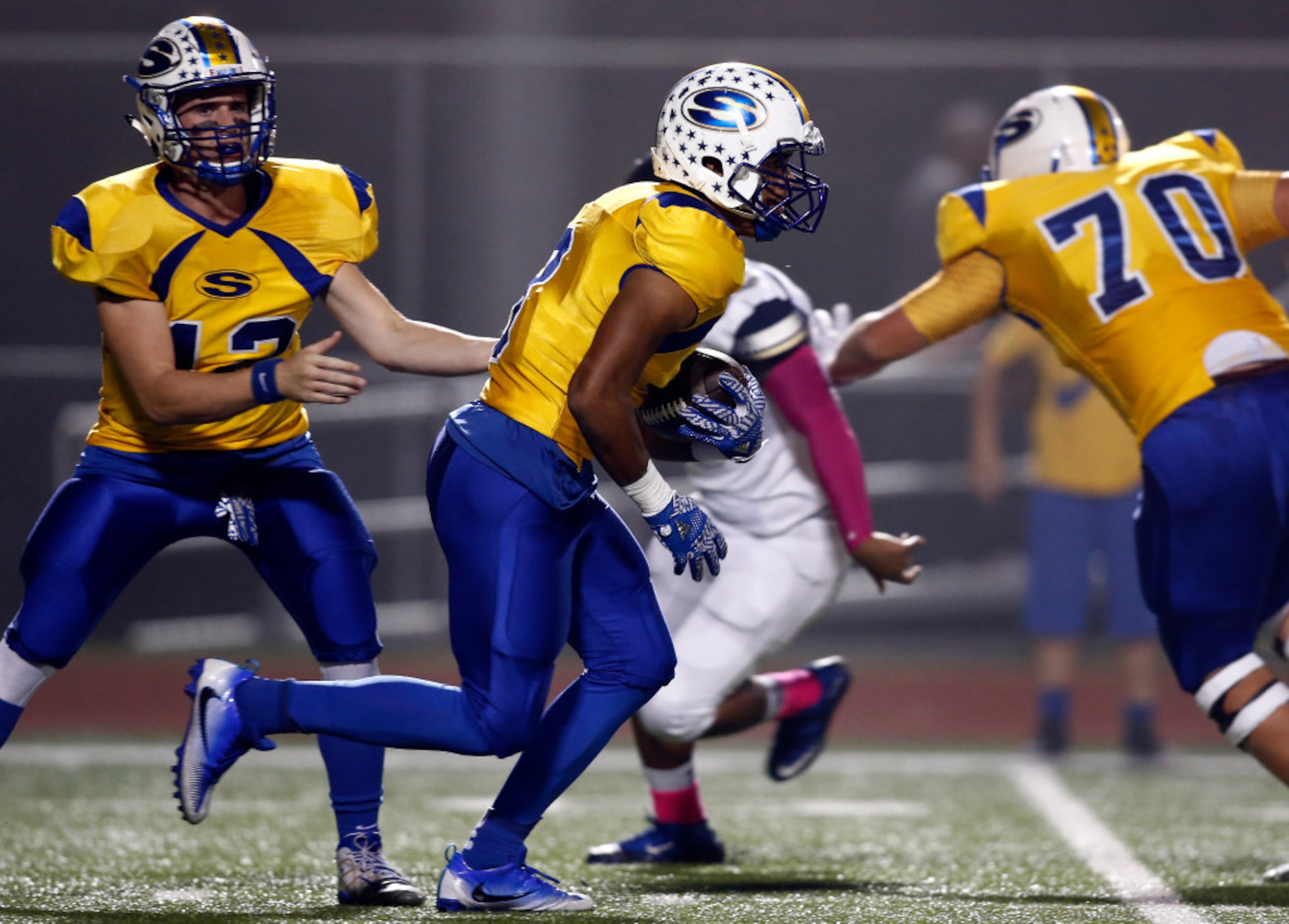 Sunnyvale running back Tre Sterling (3) takes the handoff from quarterback Caleb McDill (12)...