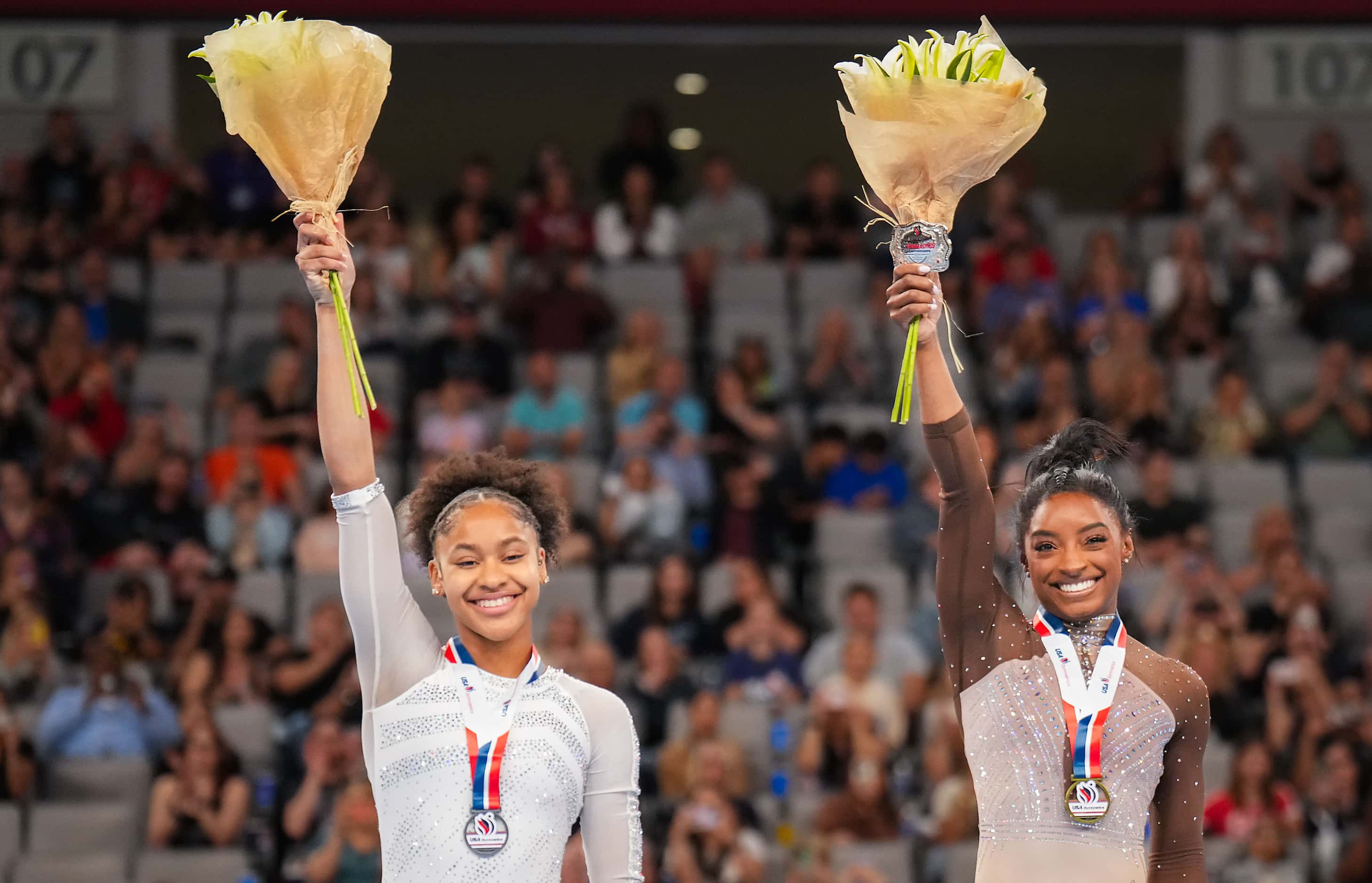 Gold medalist Simone Biles (right) and silver medalist Skye Blakely wave from the podium...