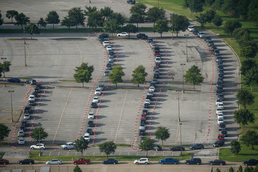 Hundreds of cars snaked through the Ellis Davis Field House parking lot as people waited to...