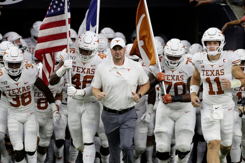 Texas head coach Tom Herman, center, takes the field with his team before an NCAA college...