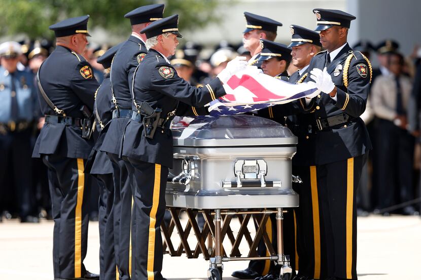 Members of the Arlington Honor Guard folded the flag during a memorial service for DART...