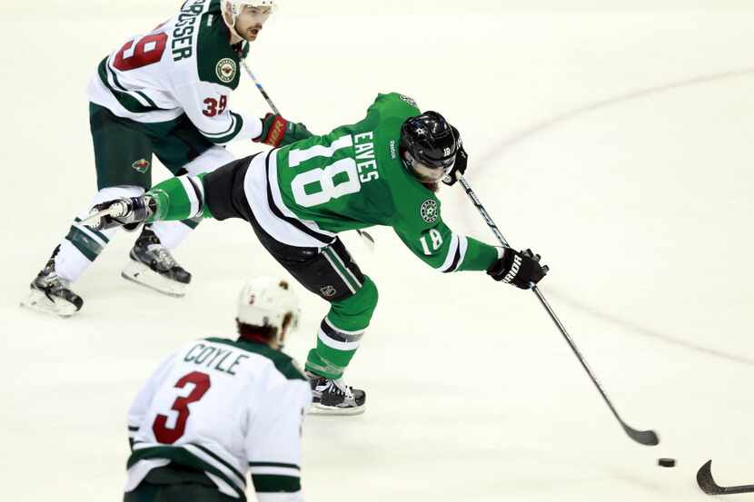 Dallas Stars right wing Patrick Eaves (18) flips a shot at the goal against the Minnesota...