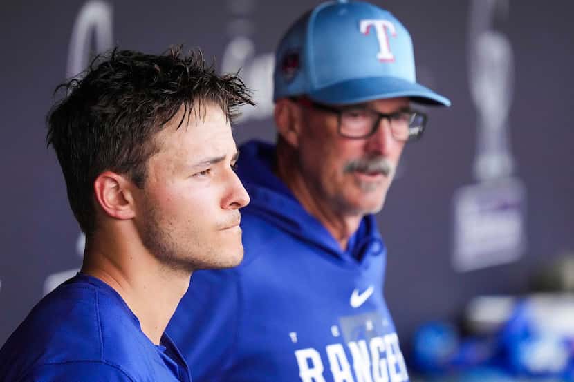 Texas Rangers pitcher Jack Leiter watches from the dugout with pitching coach Mike Maddux...