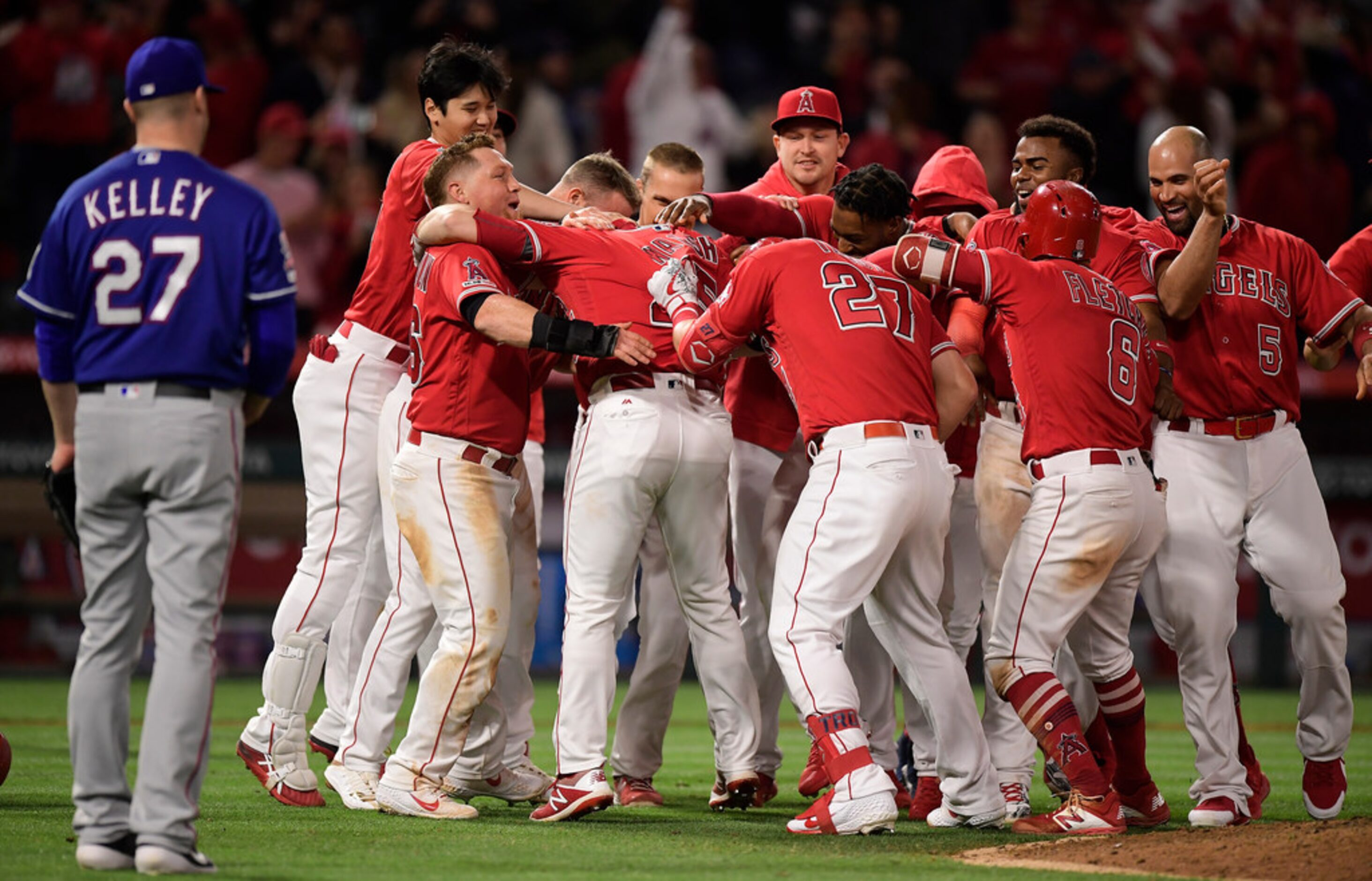 Los Angeles Angels celebrate after Jared Walsh, fourth from left, hit a walk-off single to...