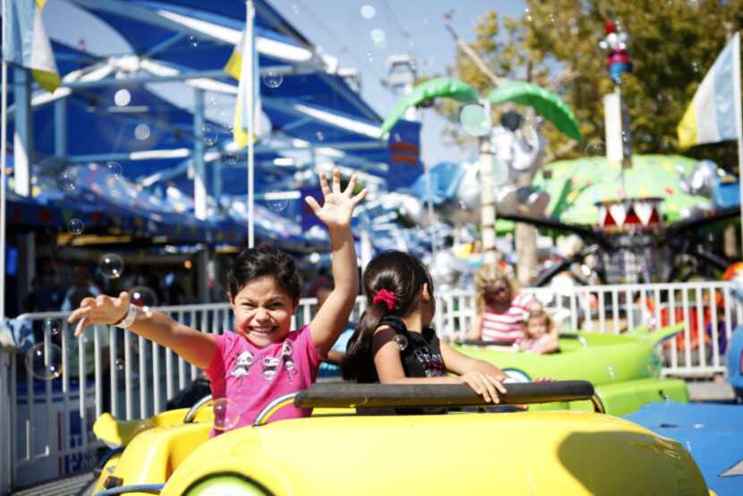 Ailani Valdez, 5 and Elsie Arizmendi, 5, brace themselves as they pass through a cloud of...