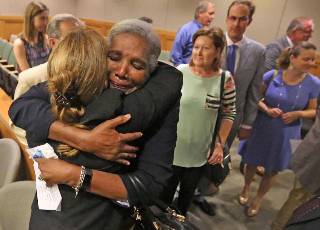 Former Judge Suzanne Wooten (left, back to camera) gets a hug from Cynthia Fitzgerald Lacy...