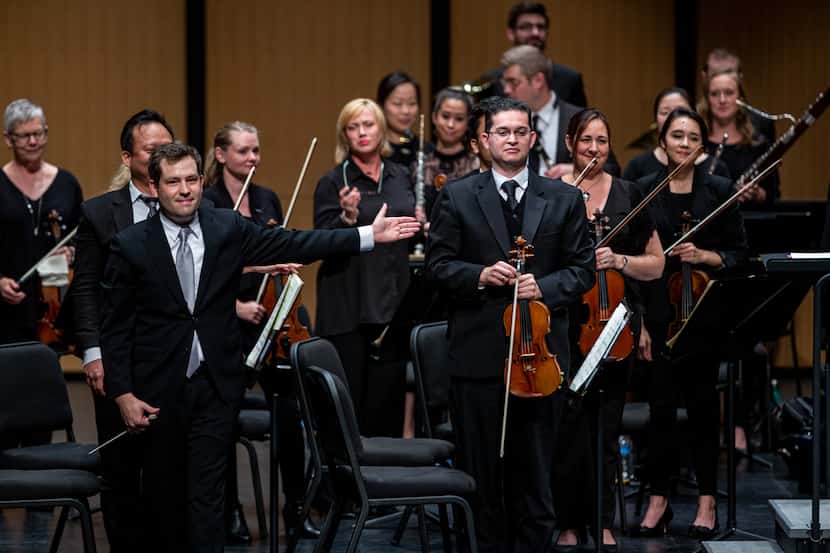Conductor Richard McKay (left) directs the audiences applause towards violinist Simon Gollo...