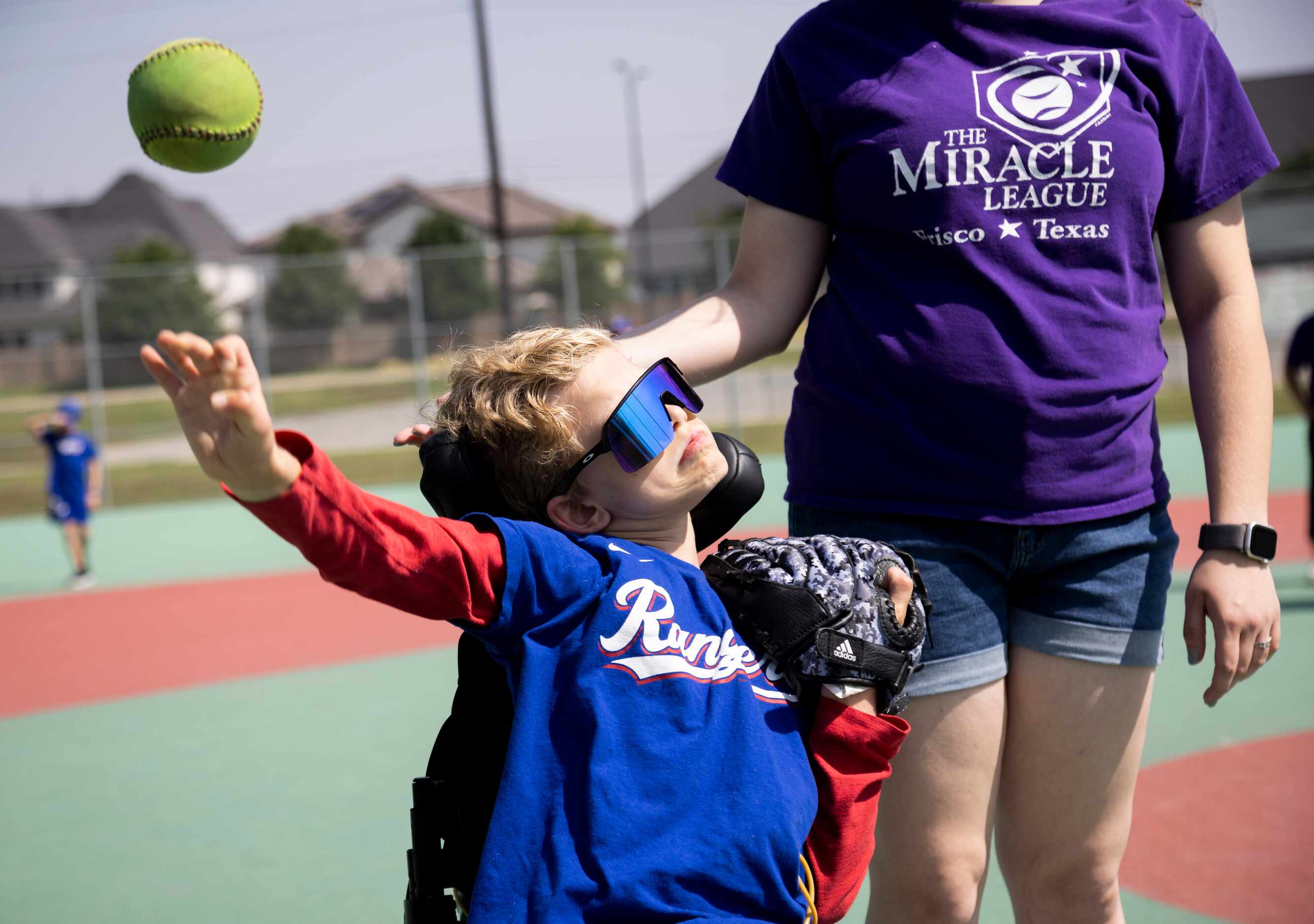 Will Woleben, 11, throws the ball next to buddy Allison McCarthy during a Miracle League...