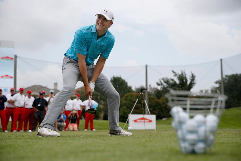 Professional golfer Jordan Spieth reacts before attempting to drive a ball with a sized-down...