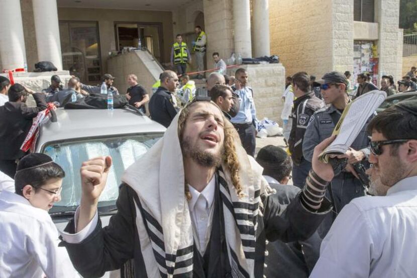 
An ultra-Orthodox Jewish man prayed at the scene of the attack. The two Palestinian...